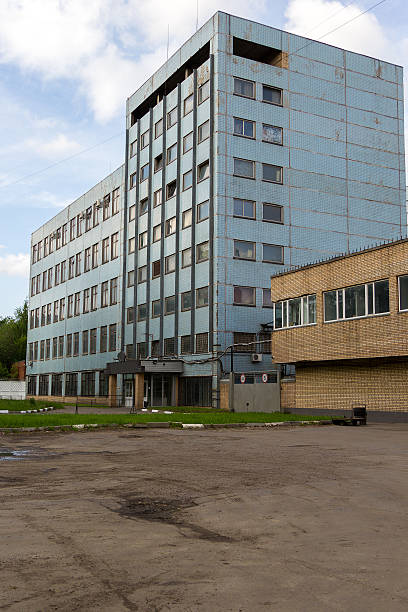 istock cracked asphalt in front of old abandoned blue office building 513055086