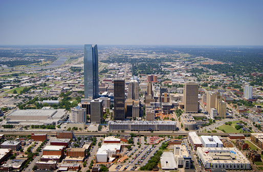 The aerial view of Oklahoma City, Oklahoma taken from a Robinson 44 helicopter with the door removed on August 15, 2014. Oklahoma City is the capital and largest city of the state of Oklahoma. The city ranks as the eighth-largest city in the United States by land area.