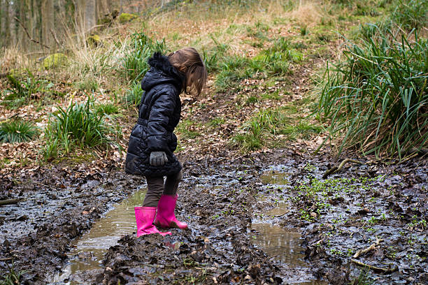 istock Child in mud on track through woodland 513056210