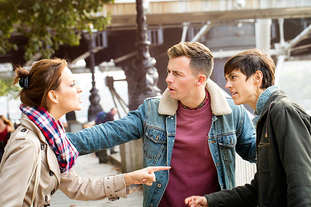 istock Young man intervenes during a fight between two women 513056332