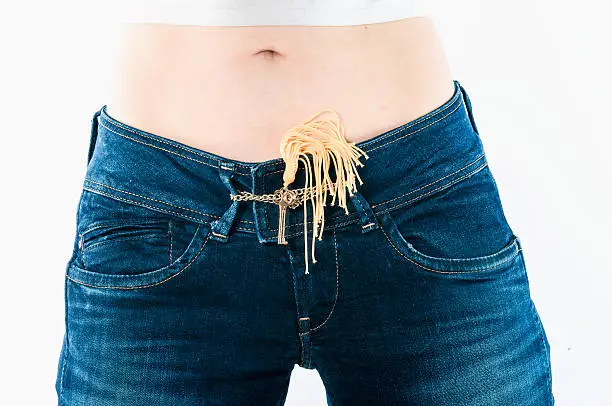 Key on the belt of women's jeans . The concept of care, chastity or safe sex .