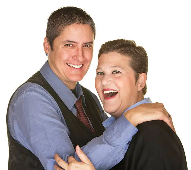 Joking lesbian couple in blue shirts on isolated background