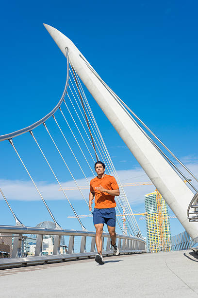 istock Male Runner Jogging Across A Bridge In San Diego 513060360