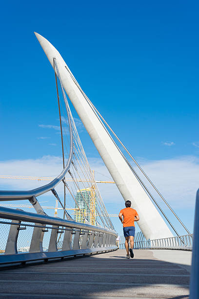 istock Male Runner Jogging Across A Bridge In San Diego 513060586