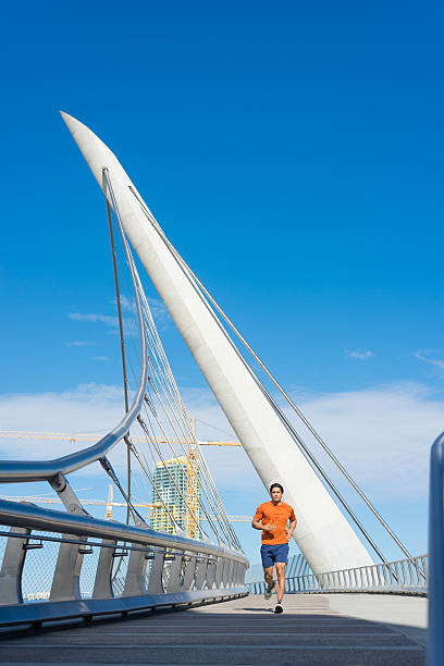 istock Male Runner Jogging Across A Bridge In San Diego 513060754
