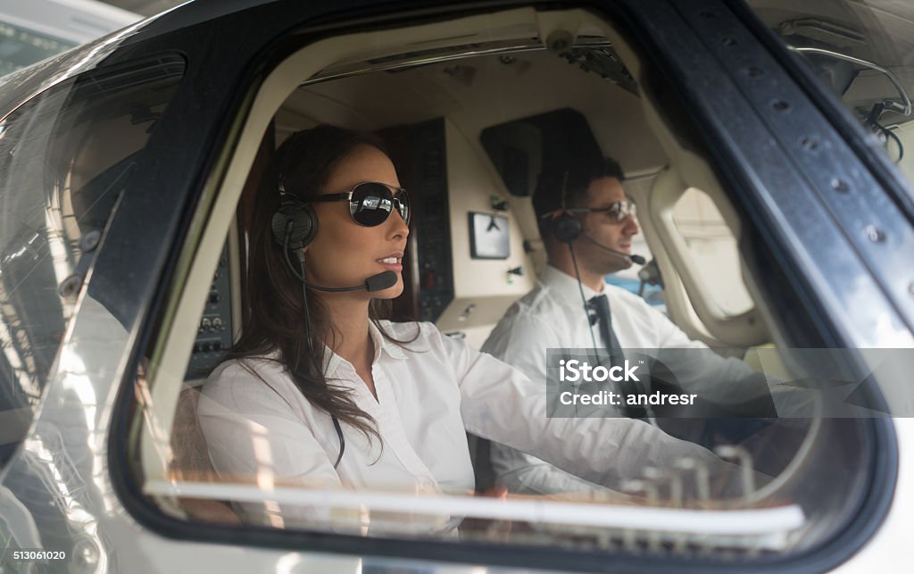 Male pilot and woman copilot traveling by helicopter Happy Latin American male pilot and woman copilot traveling by helicopter Piloting Stock Photo