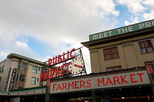 Seattle, USA - January 30, 2016: The famous landmark neon public market sign on Pike street at Pike Place Market. Shot late in the day just before sunset.
