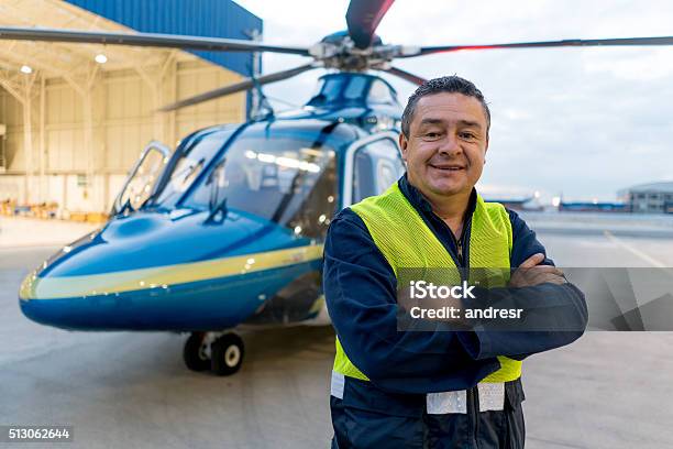 Man Working At A Helicopter Hangar Stock Photo - Download Image Now - Helicopter Pilot, Helicopter, Men