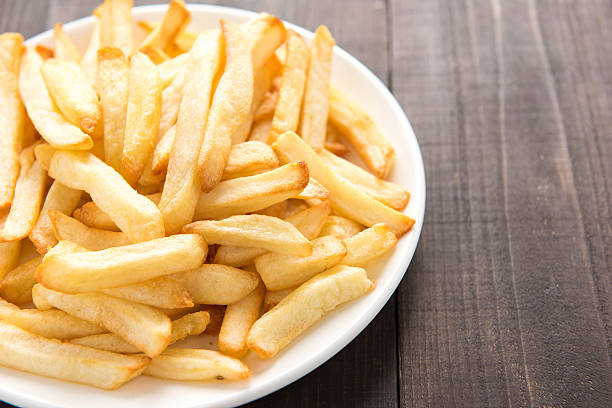 istock French fries on white dish on wooden background 513065064
