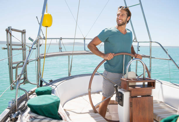 istock Man steering sailboat on water 513066225