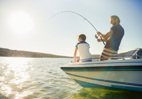Padre e hijo pescando en barco photo