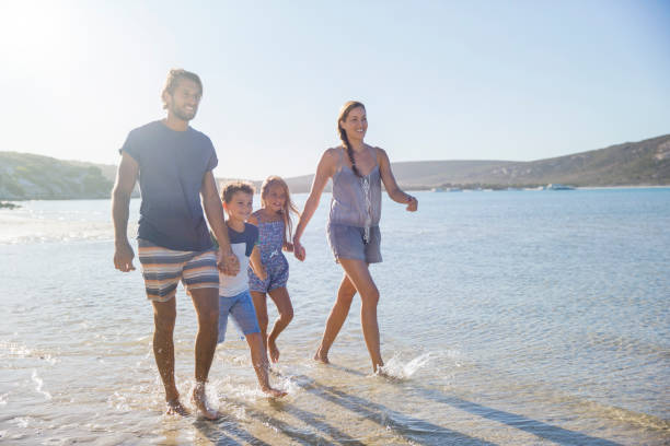 istock Family walking together along shore 513067161