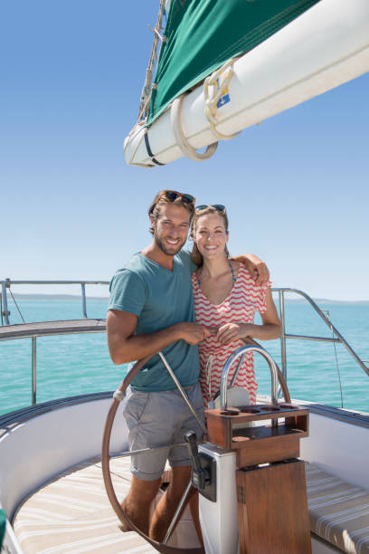 istock Couple steering sailboat together 513067169