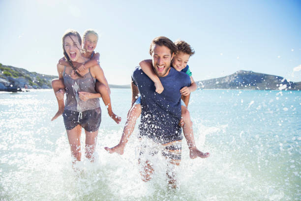 istock Family running in water on beach 513067253