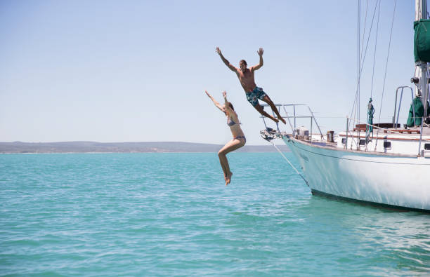 istock Couple jumping off boat into water 513067269