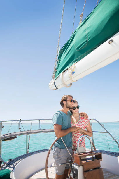 istock Couple steering sailboat together 513067277