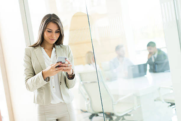 istock Young woman with mobile phone in the office 513067382