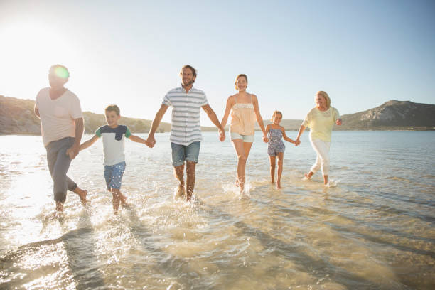 istock Family walking in shallow water on beach 513067571