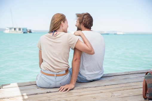 Young couple looking at view relaxing on a pier