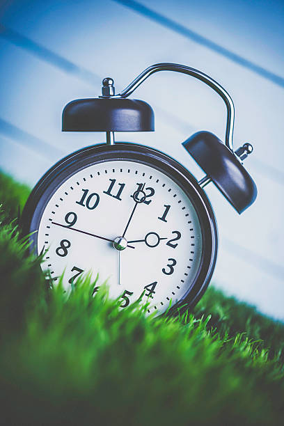 istock Clock in grass conceptualizing start of spring and DST 513068028