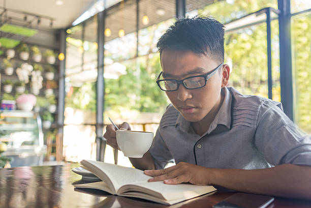 istock Asian student enjoy coffee and reading book at cafe 513068218