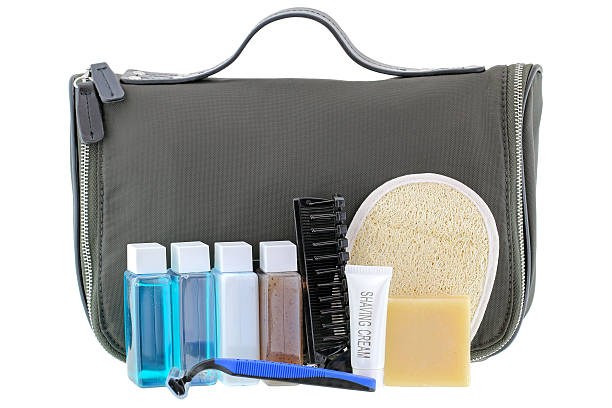 Black traveling cosmetic bag with toiletries, isolated on white Black traveling cosmetic bag with toiletries in the front, isolated on white loofah photos stock pictures, royalty-free photos & images