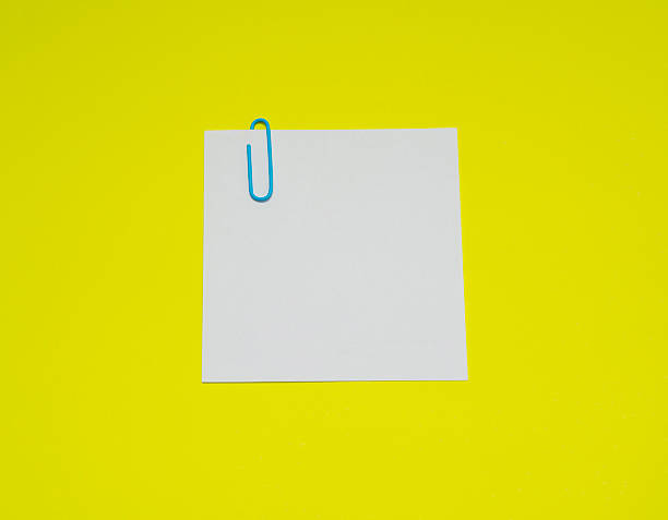 istock note with color paper clip isolated on yellow background 513069550