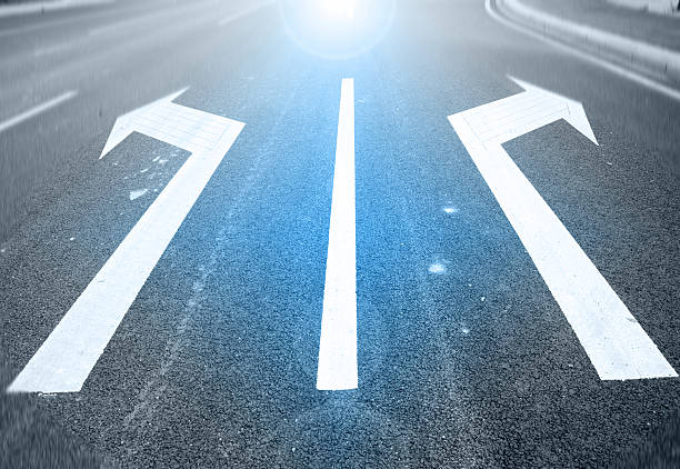 istock white painted arrow on black asphalt road 513071041