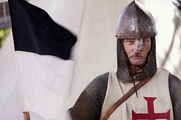 Stern Looking Knight Holding a Regimental Flag. Portrait of a Medieval Knight, taken at a re-enactment event in Stege, Denmark. chain mail stock pictures, royalty-free photos & images