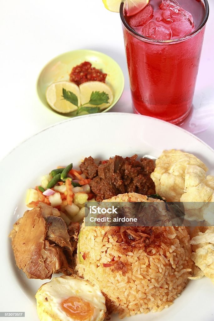 Fried Rice Fried rice or nasi goreng, served with fried chicken, egg , satay, pickles and chips Asian Culture Stock Photo