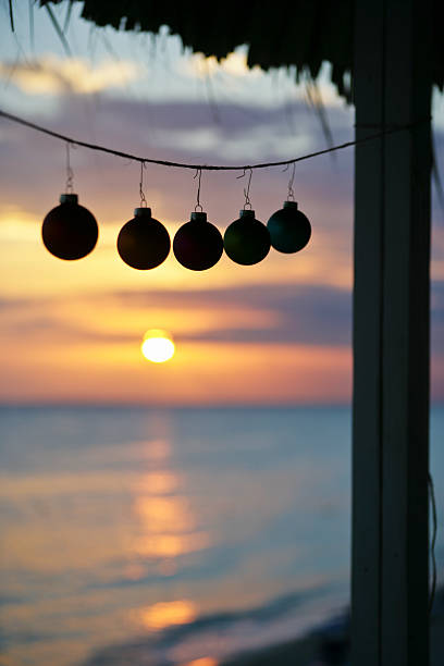 Christmas concept: Christmas baubles hanging on a tropical beach. 