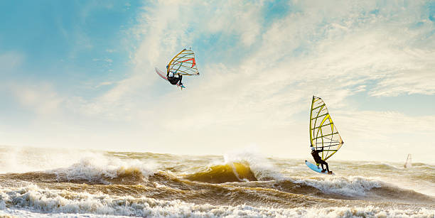 Windsurfers enjoying a stormy day in the Netherlands Windsurfers enjoying the waves on a stormy day in the Netherlands. windsurfing stock pictures, royalty-free photos & images