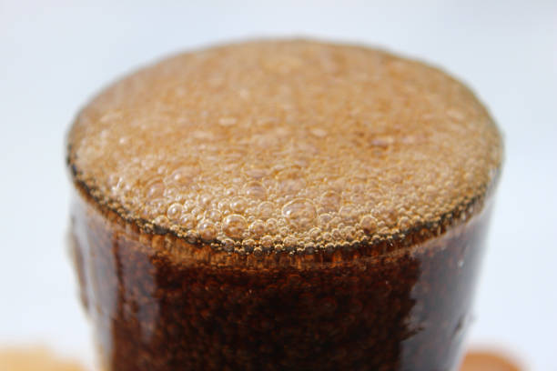 Photo showing fizzy cola being poured into an American diner style glass, making lots of bubbles appear on the surface.