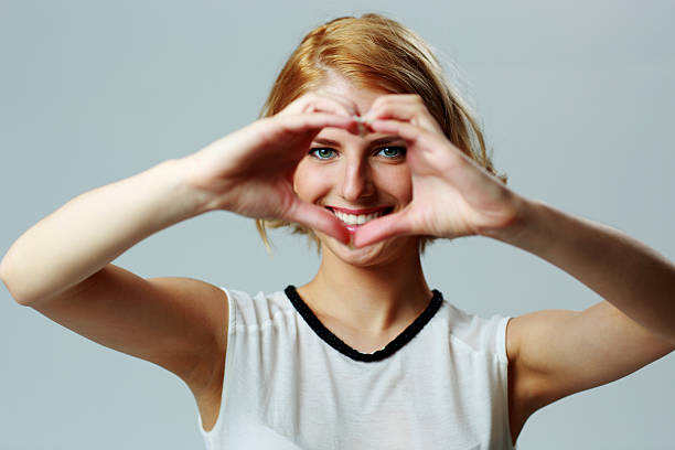 istock Happy woman making heart shape with hands 513101533