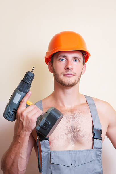 istock Man in overalls with a screwdriver 513102222