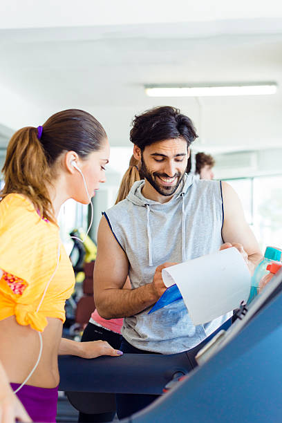 istock Woman in a gym with personal trainer. 513102267