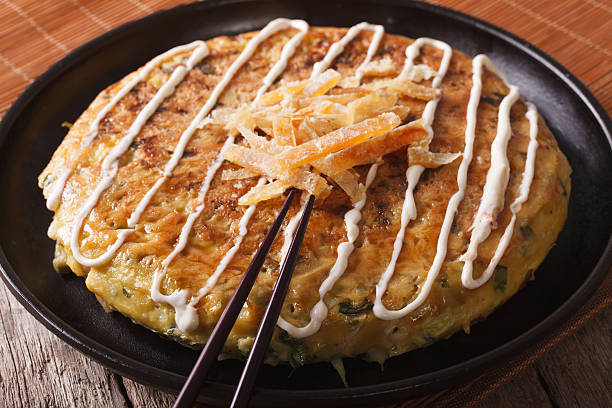istock Japanese fast food: okonomiyaki close-up and chopsticks. horizontal 513102324