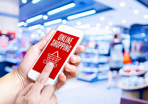 istock Hand holding mobile phone with Online shopping word with blurred 513104608