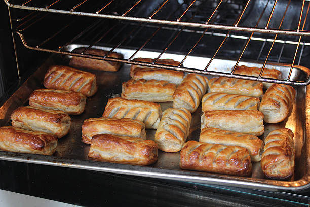 Image of freshly baked sausage rolls on oven tray, puff-pastry