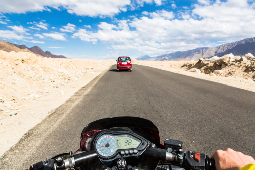 Biker driving a motorcycle in the mountain roads of Ladakh in India