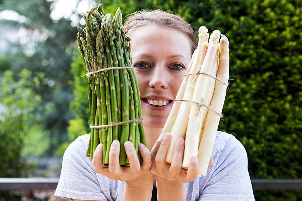 woman is holding sundry asparagus