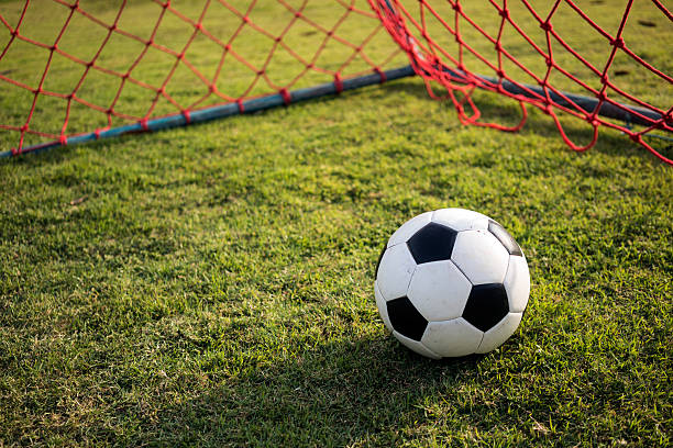 istock Football inside red goal net 3 513106600
