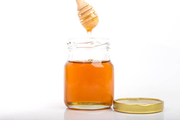 istock drizzler dripped in honey with glass jar 513109672