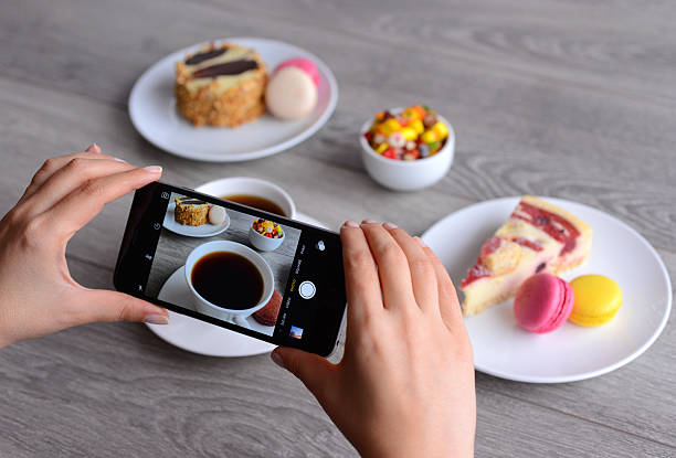 İstanbul, Turkey - January 26, 2016: Woman hands holding an Apple iPhone 6 and taking photos of a food with Instagram application. iPhone is a touchscreen smart phone produced by Apple Inc.
