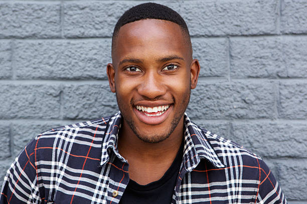 istock Cheerful young african guy smiling against gray wall 513110422