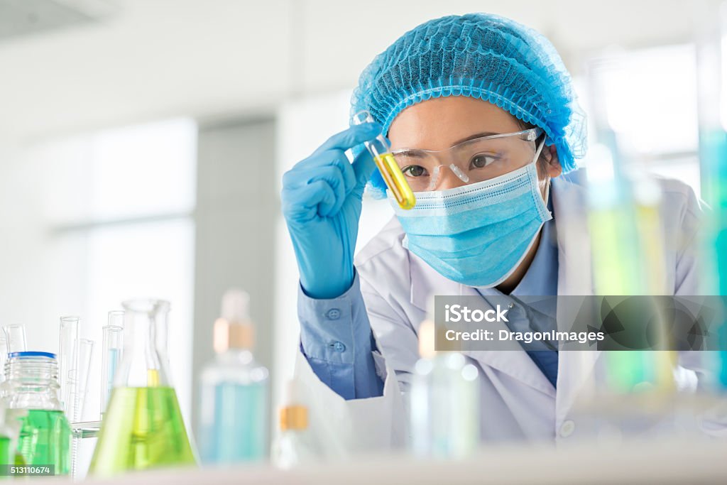 Result of research Vietnamese researcher looking at test-tube with result of experiment Scientist Stock Photo