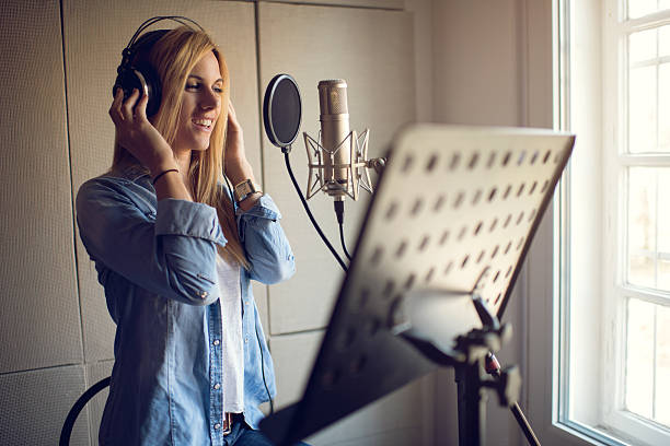 souriant chanteur enregistrement en studio de musique. - singer singing women microphone photos et images de collection