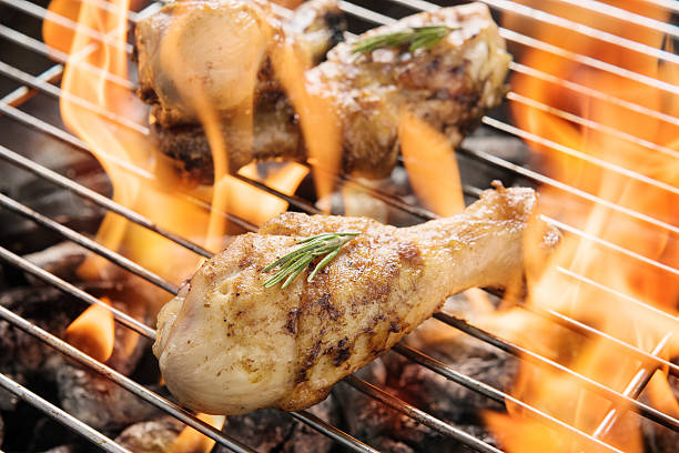 istock Chicken drumsticks grilling over flames on a barbecue 513110996