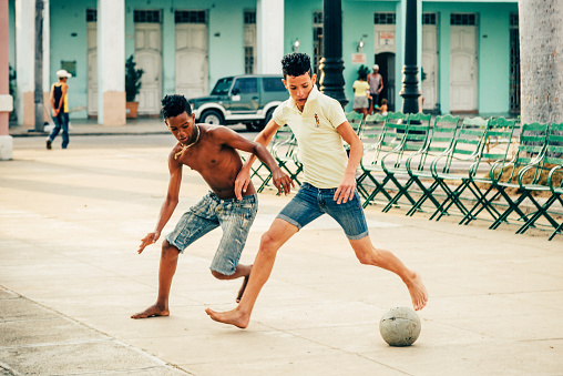 Cienfuegos, Cuba - March 22, 2015: Two Cuban boys playing soccer in the Parque Marti in Cienfuegos.