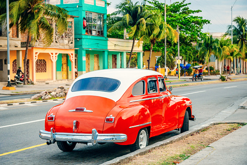 Red American car parking at a street of Cienfuegos, Cuba